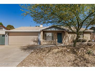 Charming single-story home with a well-maintained lawn, brick facade, and a two-car garage at 5423 S Palm Dr, Tempe, AZ 85283