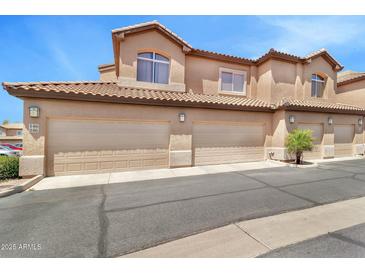 Inviting townhome features multiple garages and classic Southwestern architecture with tile roof at 6535 E Superstition Springs Blvd # 146, Mesa, AZ 85206