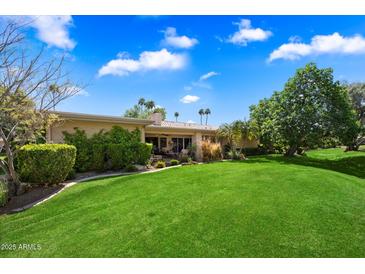 Expansive backyard with lush lawn and mature landscaping offering serene outdoor living at 7746 E Bisbee Rd, Scottsdale, AZ 85258