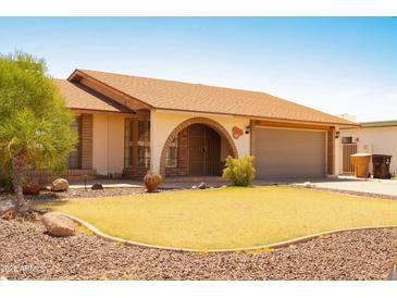 Charming single-story home featuring a well-maintained lawn and a two-car garage at 10603 W Ruth Ave, Peoria, AZ 85345