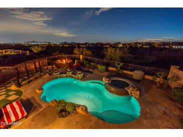Aerial view showcasing the backyard pool, fire pit area, landscaping, and the surrounding desert landscape at 18438 N 96Th Way, Scottsdale, AZ 85255
