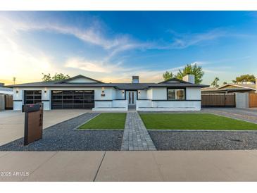 Charming home exterior with fresh green grass, a paved walkway, a modern garage door, and stylish accents at 1868 E La Donna Dr, Tempe, AZ 85283