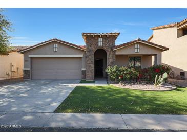 Charming single-story home featuring a well-maintained lawn and a two-car garage at 2181 E 27Th Ave, Apache Junction, AZ 85119