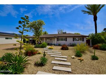 Charming single-story home featuring desert landscaping, a stone pathway, and a well-maintained front yard at 3015 E Sells Dr, Phoenix, AZ 85016