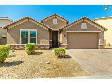 Charming single-story home featuring a well-maintained front yard and a two-car garage with a brick-paved driveway at 5218 W Lydia Ln, Laveen, AZ 85339