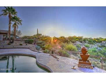 Desert landscaping surrounds the pool with a water feature and palm trees with a view at 16304 E Crystal Ridge Dr, Fountain Hills, AZ 85268