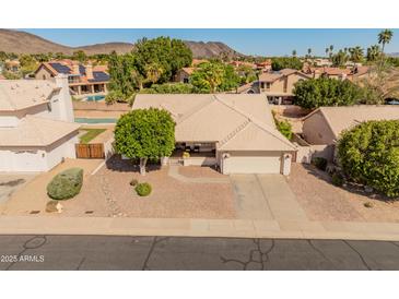 Attractive single-story home with desert landscaping, charming front porch, and convenient attached two-car garage at 21335 N 64Th Ave, Glendale, AZ 85308