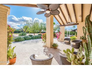 Charming outdoor patio with comfortable seating and a beautiful view of the landscaped garden and blue skies at 22633 N Clubhouse Way, Scottsdale, AZ 85255