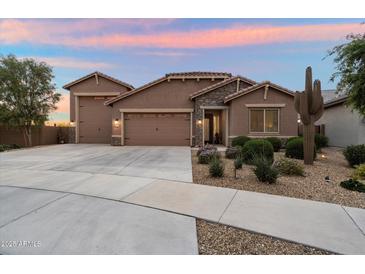 Beautiful single-story home featuring a three-car garage, desert landscaping, and a charming stone facade at 24280 N 164Th Dr, Surprise, AZ 85387