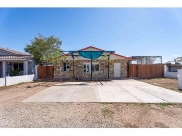 Charming home with a stone facade, a red roof, and a large concrete parking pad at 2445 W Yuma St, Phoenix, AZ 85009