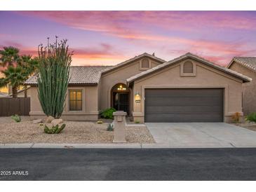 Beautiful single-story home featuring a two-car garage, desert landscaping, and a sunset backdrop at 4020 N 151St Dr, Goodyear, AZ 85395