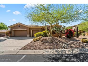 Charming home with a xeriscaped front yard, mature landscaping, and a two-car garage at 41910 N Long Cove Way, Anthem, AZ 85086