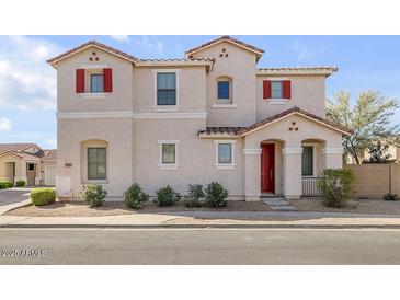 Two story home with red door and red shutters, beige stucco and desert landscaping at 935 E Redondo Dr, Gilbert, AZ 85296