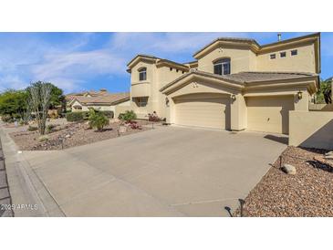Stunning two-story home boasts a three-car garage and desert landscaping, showcasing curb appeal at 13827 N Mesquite Ln, Fountain Hills, AZ 85268