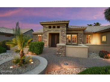 Inviting front exterior with desert landscaping and stone accents, showcasing a charming entrance at 15109 W Waterford Dr, Surprise, AZ 85374