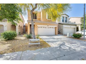 Charming two-story home showcasing a xeriscaped front yard with a mature tree providing shade at 1633 W Lacewood Pl, Phoenix, AZ 85045