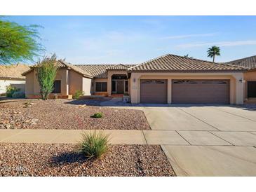 Charming single-story home featuring a well-maintained landscape, a two-car garage, and tile roofing at 2449 E Desert Flower Ln, Phoenix, AZ 85048