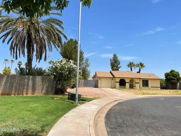 Charming single-story home featuring desert landscaping, a two-car garage, and mature palm trees at 2834 E Juanita Ave, Mesa, AZ 85204