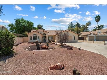 Charming single-story home with desert landscaping and a tile roof under a partly cloudy sky at 63 W Los Arboles Dr, Tempe, AZ 85284