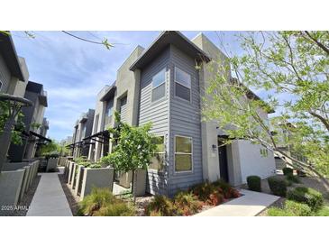 Modern two-story townhome featuring stylish gray siding and professionally landscaped front yard at 7531 E Billings St # 123, Mesa, AZ 85207