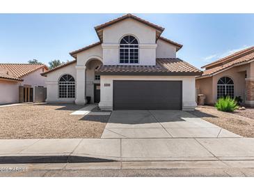 Charming two-story home with an arched entry, tile roof, desert landscaping, and a two car garage at 7869 W Market St, Glendale, AZ 85303
