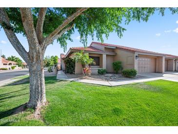 Charming single-story home featuring a well-maintained lawn and desert landscaping at 945 N Pasadena -- # 35, Mesa, AZ 85201