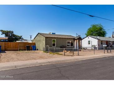 View of the exterior of the property with fence and gravel landscape at 1424 S Bonarden Ln, Tempe, AZ 85281