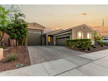 Inviting home showcasing a spacious driveway and beautifully landscaped front yard at 17813 W Pinnacle Vista Dr, Surprise, AZ 85387