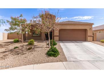 Charming single-story home with a well-manicured front yard and a two-car garage at 19887 N Herbert Ave, Maricopa, AZ 85138