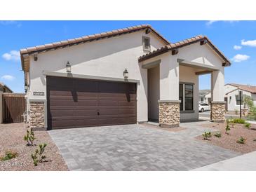 Charming single-Gathering home showcasing a two-car garage, stone accents, and a well-maintained front yard at 20302 W Turney Ave, Buckeye, AZ 85396