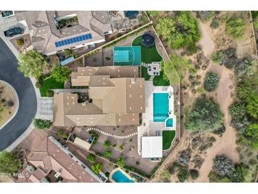 Expansive property with a sparkling pool, basketball court, and multiple patio areas, surrounded by lush landscaping at 30129 N 52Nd Pl, Cave Creek, AZ 85331