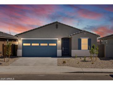 Charming single-story home featuring a blue garage door and desert landscaping at sunset at 37126 W Prado St, Maricopa, AZ 85138