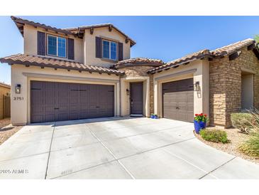 Charming two-story home with a three-car garage, stone accents, and a well-maintained front yard at 3751 E Zachary Dr, Phoenix, AZ 85050