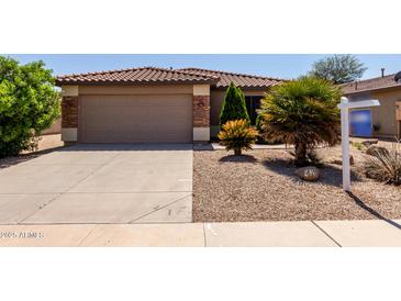 Charming home featuring a two-car garage, desert landscaping, and a red tile roof at 42311 W Bunker Dr, Maricopa, AZ 85138