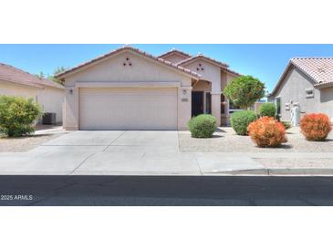 Charming single-story home showcasing a well-maintained front yard with a spacious two-car garage at 426 N Santiago Trl, Casa Grande, AZ 85194