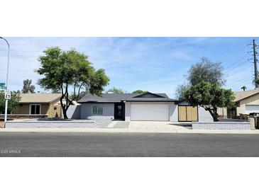 Charming single-story home features a gray exterior, well-manicured yard, and a two-car garage at 5007 N 71St Dr, Glendale, AZ 85303