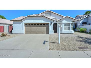 Charming single-story home featuring a well-manicured front yard, two-car garage and desert landscaping at 5226 W Pontiac Dr, Glendale, AZ 85308
