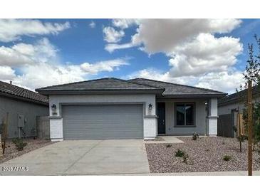 Charming single-story home featuring a gray color scheme, a two-car garage, and a well-maintained front yard at 16996 W Fetlock Trl, Surprise, AZ 85387