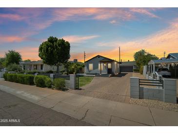 Charming home with a beautifully landscaped front yard and a brick driveway, under a colorful dusk sky at 2316 N Mitchell St, Phoenix, AZ 85006