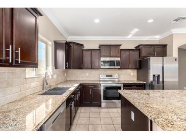 Kitchen featuring dark cabinetry, stainless steel appliances, and granite countertops at 23789 W Chipman Rd, Buckeye, AZ 85326