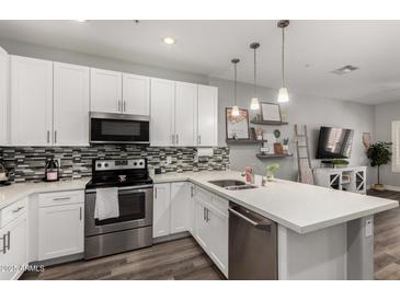 Well-lit kitchen with white cabinets, stainless steel appliances, and decorative backsplash at 2821 S Skyline -- # 135, Mesa, AZ 85212