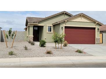 Charming single-story home featuring a two-car garage, landscaped front yard, and a welcoming entrance at 323 S San Fernando Ln, Casa Grande, AZ 85194