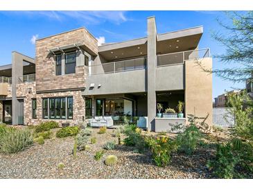 Contemporary home featuring a multi-level deck, desert landscaping, and a seamless indoor-outdoor living space at 37200 N Cave Creek Rd # 1122, Scottsdale, AZ 85262