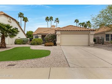 Inviting single-story home with a tile roof, desert landscaping, and a two-car garage at 4031 N Ranier --, Mesa, AZ 85215