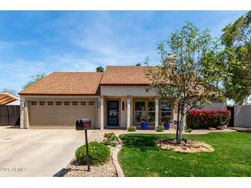 Inviting home exterior showcasing a well-maintained lawn and attractive landscaping, plus a two-car garage at 4525 E Desert View Dr, Phoenix, AZ 85044
