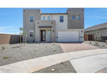 Modern two-story home featuring a spacious two car garage, minimalist desert landscaping, and a welcoming front entrance at 14739 W El Cortez Pl, Surprise, AZ 85387