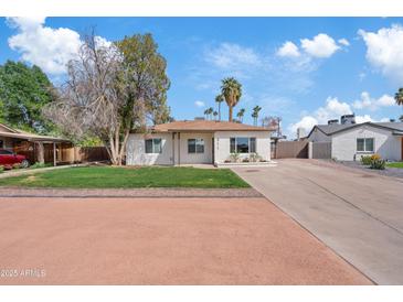 Charming single-story home with a well-maintained front yard, a long driveway, and a traditional design at 311 N Henkel --, Mesa, AZ 85201