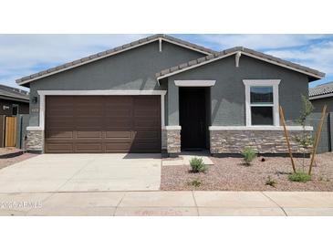Charming single-story home featuring a brown garage door, stone accents, and a well-maintained front yard at 3582 E Audrey Dr, San Tan Valley, AZ 85143