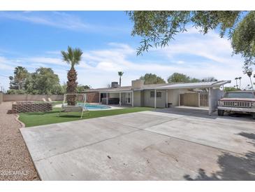 Large backyard showcasing a pool, brick fire pit, covered patio and parked car at 530 E Draper St, Mesa, AZ 85203