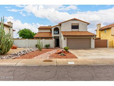 Charming two-story home featuring a desert landscape, two-car garage, and red tile roofing at 5407 W North Ln, Glendale, AZ 85302